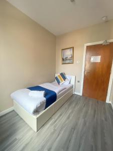 曼彻斯特Park Crescent Hotel的一间卧室设有一张大床和一扇木门
