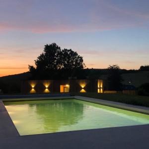 MontLes Tiny House du Mas de Mont的日落时在房子后院的游泳池