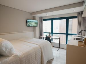 圣保罗Apê Paulista Bela Cintra的卧室配有一张床,墙上配有电视。
