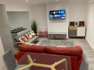 KentBeautiful 5Bedroom Hse-Contractor/Family/Corporate的客厅配有红色沙发和电视