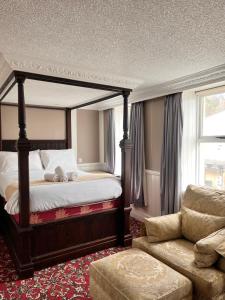 兰迪德诺玫瑰托尔酒店的一间卧室配有天蓬床和沙发