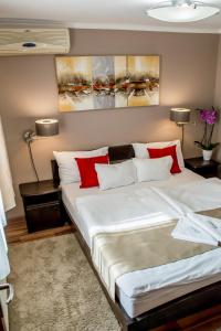 加尔多尼MeDoRa Park - Hotel MeDoRa***的卧室配有带红色枕头的大型白色床