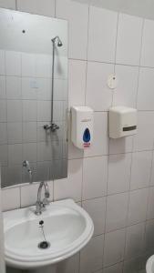 金贾Arise Africa International Christian Guesthouse的白色的浴室设有水槽和镜子