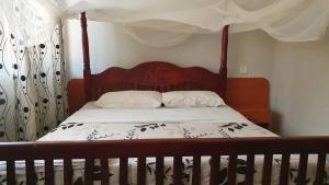 金贾Arise Africa International Christian Guesthouse的一间卧室配有一张木床和天篷