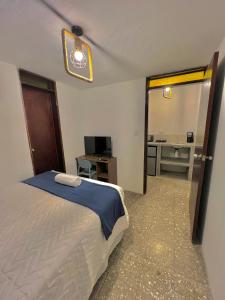 危地马拉Hotel Citadin Z10的一间卧室配有一张床、一张书桌和一面镜子