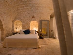 塞尔瓦迪法萨诺Nina Trulli Resort的卧室配有砖墙内的床铺
