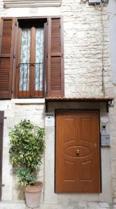 鲁沃迪普利亚La Petite Maison的一座带棕色门和两扇窗户的建筑