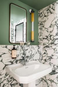 巴黎Hôtel Chamar的一间带水槽和镜子的浴室