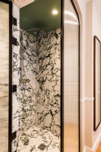 巴黎Hôtel Chamar的带淋浴的浴室(带石墙)