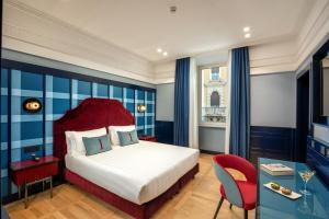 罗马独立酒店的酒店客房,配有一张床和一张红色椅子