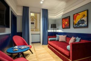 罗马独立酒店的客厅配有红色沙发和红色椅子