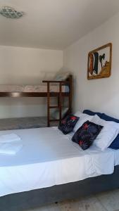 卡诺格布拉达Suítes Preguiça的一张位于房间的床,上面有两个枕头