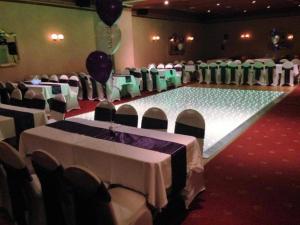 阿洛厄OYO Dunmar House Hotel的宴会厅配有白色和绿色的桌椅