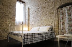 鲁沃迪普利亚La Petite Maison的一间砖墙内白色床的卧室