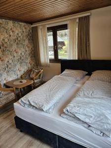 托特莫斯Am Wehrastrand App 2的一间卧室设有两张床、一张桌子和一个窗口