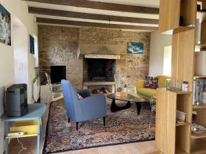 劳恩尼克Maison bretonne en pierre avec WIFI et piscine couverte à LOUANNEC - Réf 846的客厅设有壁炉和蓝椅