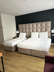 霍夫多普MA Airport Hotel的两张睡床彼此相邻,位于一个房间里