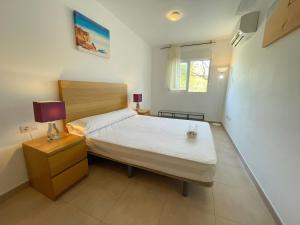 阿尔考斯布里Apartamentos Neptuno 3000的一间小卧室,配有床和床头柜