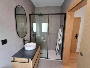 MoreiraOPORTO Suites的浴室配有盥洗盆和带镜子的淋浴