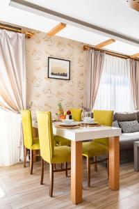 安塔利亚Loi Suite的一间带桌子和黄色椅子的用餐室