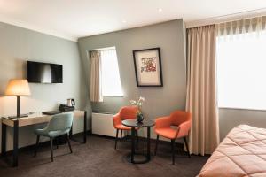 布鲁日阿拉贡酒店的酒店客房,配有一张床、一张桌子和椅子