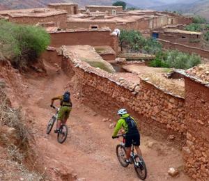 拉拉塔可库斯特Tiki House Marrakech chez Paul的两个人骑着自行车沿着土路走