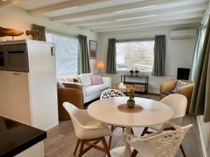 芬克芬New- Private Cosy Houseboat, on a lake near Amsterdam的厨房以及带桌椅的起居室。