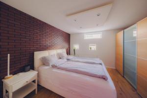凯夫拉维克Smart Luxury - Private Gym, Hot Tub & Sauna的一间卧室设有砖墙和一张床