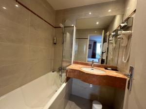 巴黎法兰西埃菲尔酒店的浴室配有水槽、淋浴和浴缸。