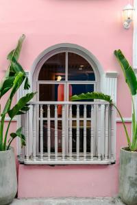 卡塔赫纳Sublime Hotel Boutique Cartagena的粉红色的房子,有白色的栏杆和窗户