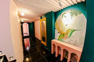 卡塔赫纳Sublime Hotel Boutique Cartagena的墙上挂着鸟壁画的走廊