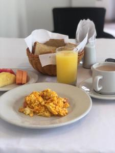 卡塔赫纳圣马丁卡塔赫纳酒店的一张桌子,上面放着一盘食物和一杯橙汁