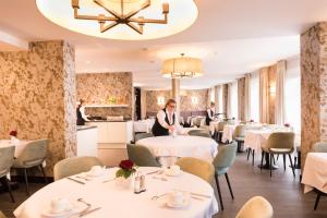 布鲁日阿拉贡酒店的一间设有白色桌椅的用餐室