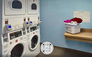 孟菲斯Sonesta Simply Suites Memphis East Poplar Pike的洗衣机以及位于柜台的洗衣篮