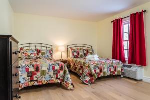 Fort Coulonge斯普斯赫尔姆旅馆的配有红色窗帘的客房内的两张床