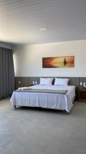 拉巴拉德纳圣米格尔Pousada Cantinho da Barra的一间卧室配有一张带白色床单的大床