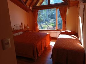 托尔胡因Hostería Rutalsur的一间卧室设有两张床和大窗户