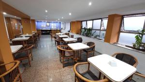 尤西德福拉César Inn Juiz de Fora Hotel的用餐室设有桌椅和窗户。