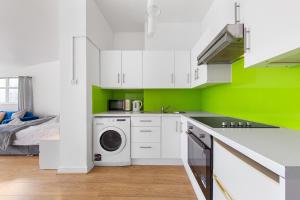 伦敦Spacious Studio High Street Location的厨房配有白色橱柜和绿色墙壁