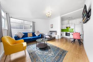 伦敦Spacious Studio High Street Location的客厅配有蓝色的沙发和桌子