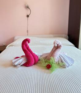 萨拉热窝Avlija Garden Gem的躺在床上的人,带粉红色毛巾