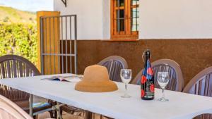 AlmácharCasa Rocio Almachar by Ruralidays的一张带帽子和两杯酒杯的桌子