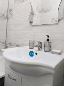 阿克托比12 Microragion Apartments的浴室设有白色水槽和镜子