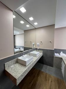 托莱多Nayru Hotel的一间带两个盥洗盆和大镜子的浴室