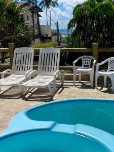 伊列乌斯Princesinha do Sul的游泳池旁的三把白色椅子