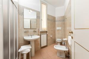 锡耶纳密涅瓦酒店的一间带水槽、卫生间和镜子的浴室