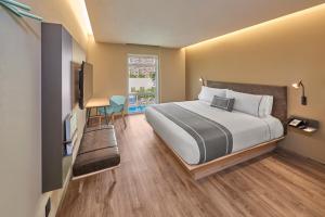 恩塞纳达港City Express Plus by Marriott Ensenada的一间卧室配有一张大床和电视
