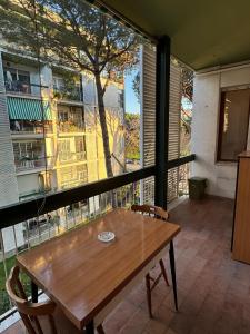 罗马Umanesimo Resort Apartment的阳台配有桌椅和大窗户