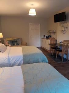布拉尼Mulberry Lodge的一间带两张床和一张桌子的卧室以及一间厨房
