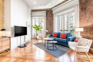 伦敦Premium Belgravia Harrods Apartment的客厅配有蓝色的沙发和电视